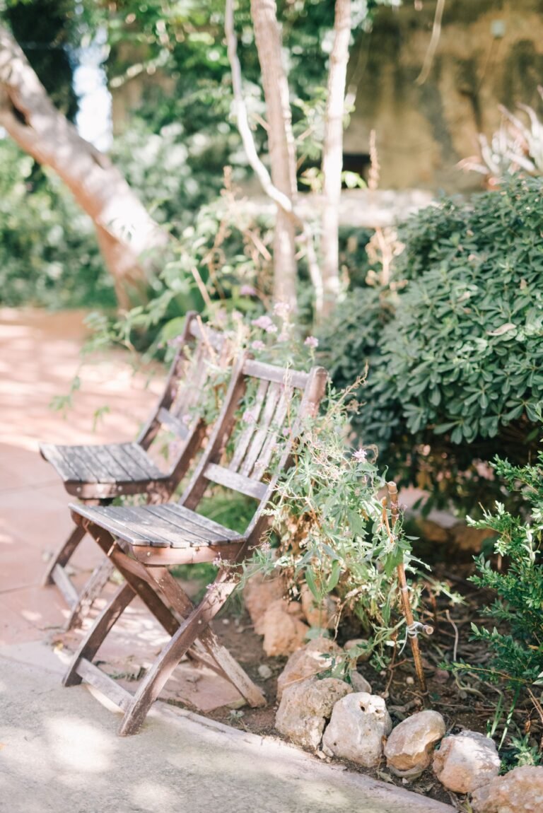 Two weathered wooden folding chairs in a garden